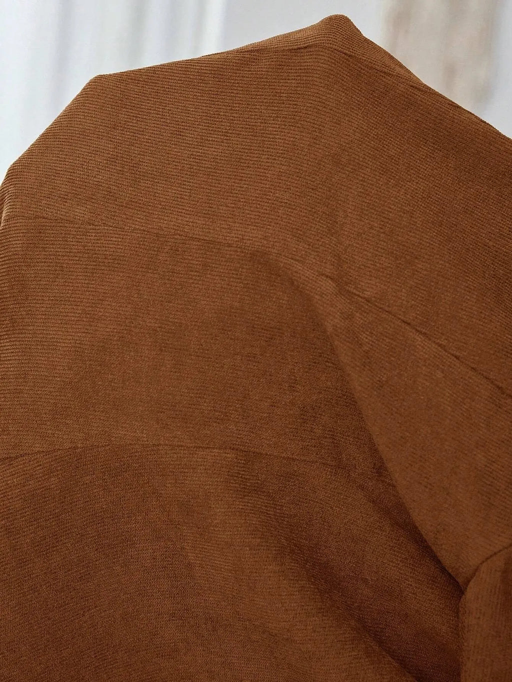 Brown long sleeve single-breasted suit coat with lapel collar on a hanger.