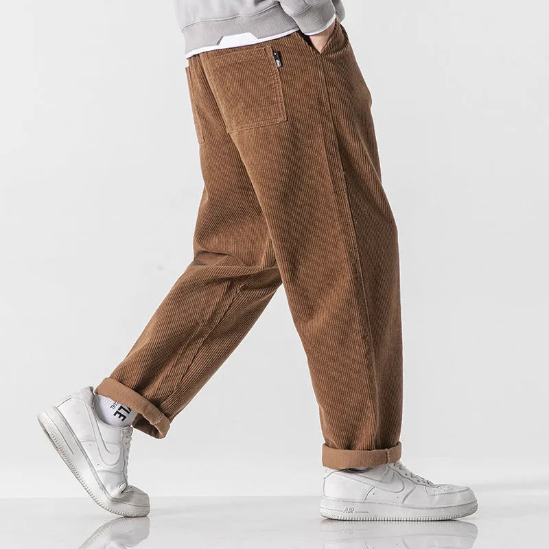 Men's loose straight-leg corduroy sports trousers in army green, laid flat to show fit and texture.