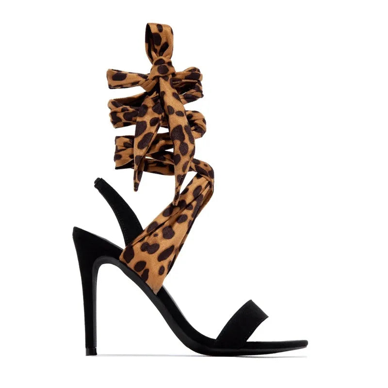 Light brown leopard print women's high heels with cross-straps and a tall stiletto heel.