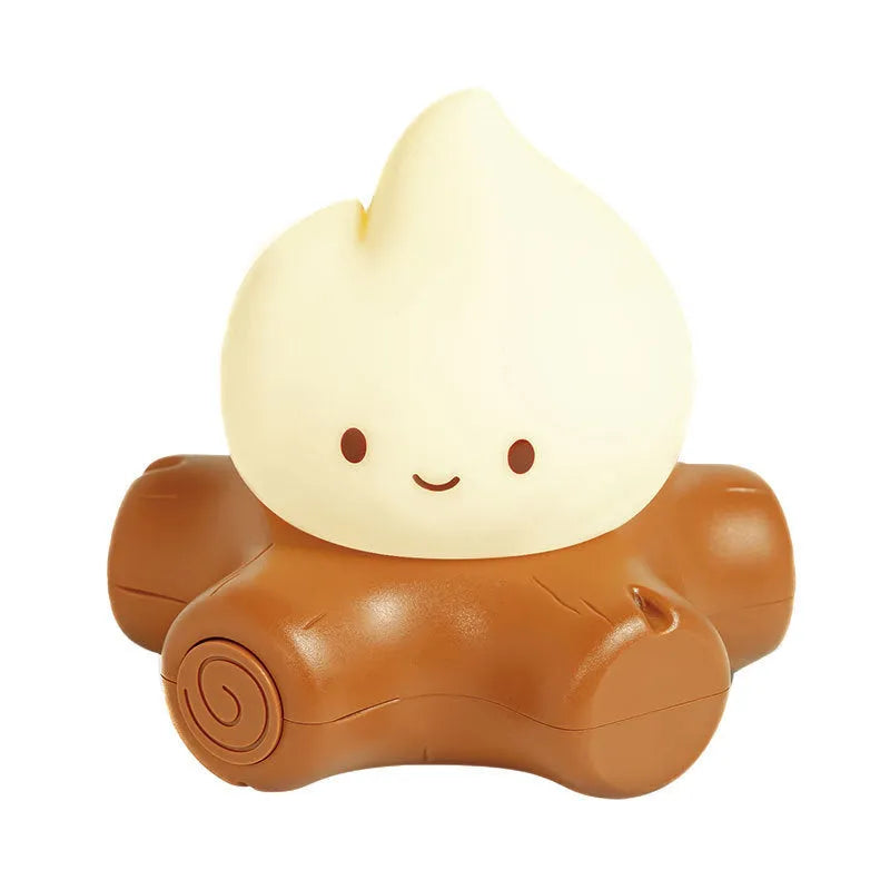 Small yellow silicone night lamp with cartoon fire pile design on a table.