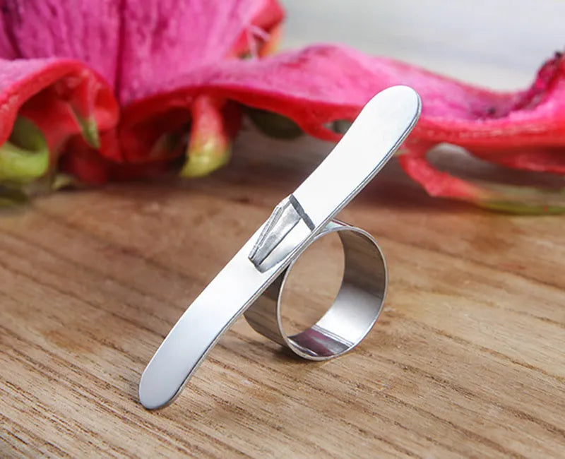 Silver stainless steel finger ring fruit peeler for citrus and pomegranates.