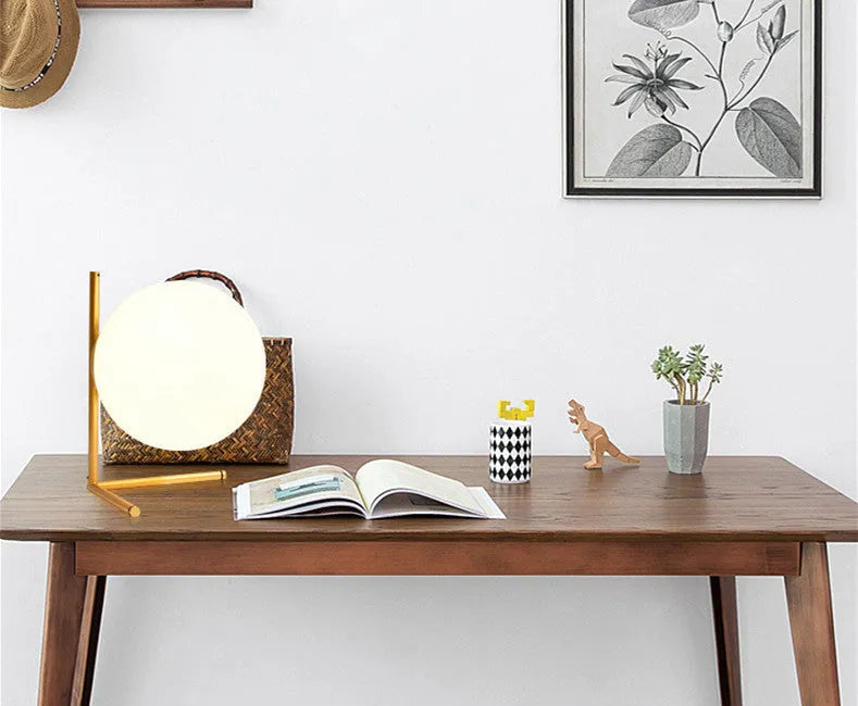 Creative glass desk lamp with three-tone LED lighting on a wooden desk.
