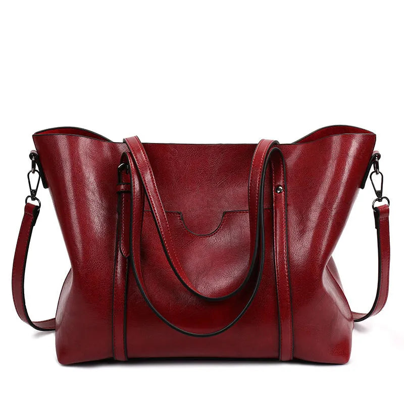 Brown retro messenger bag for women with large main compartment, shown next to a wallet and A4 magazine for scale.