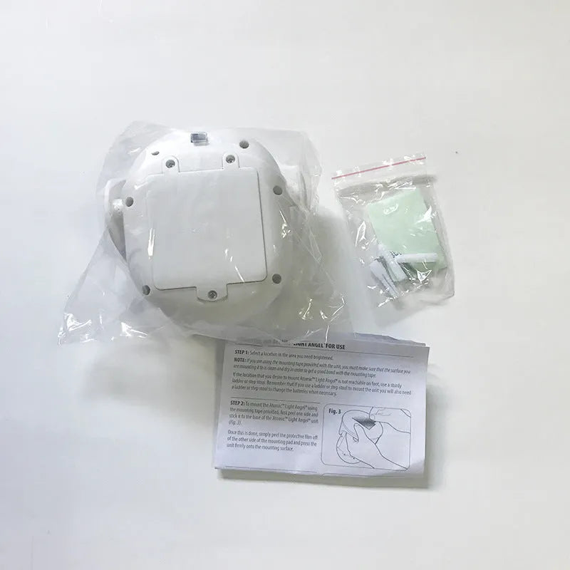 White Atomic Angel shaped induction night light on a surface.