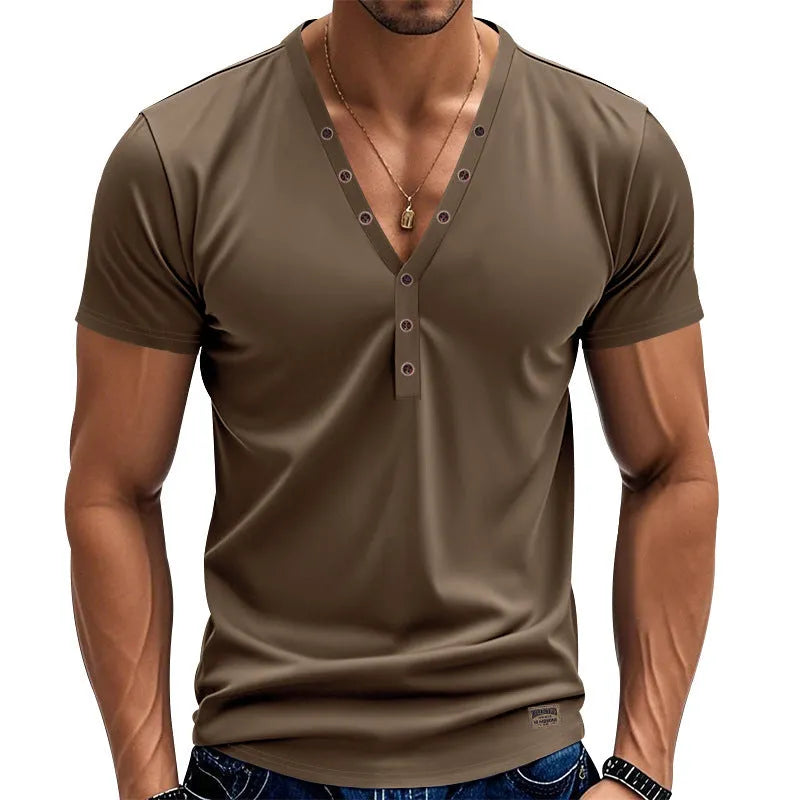 Man wearing a loose fit light blue V-neck pullover top with a button detail.