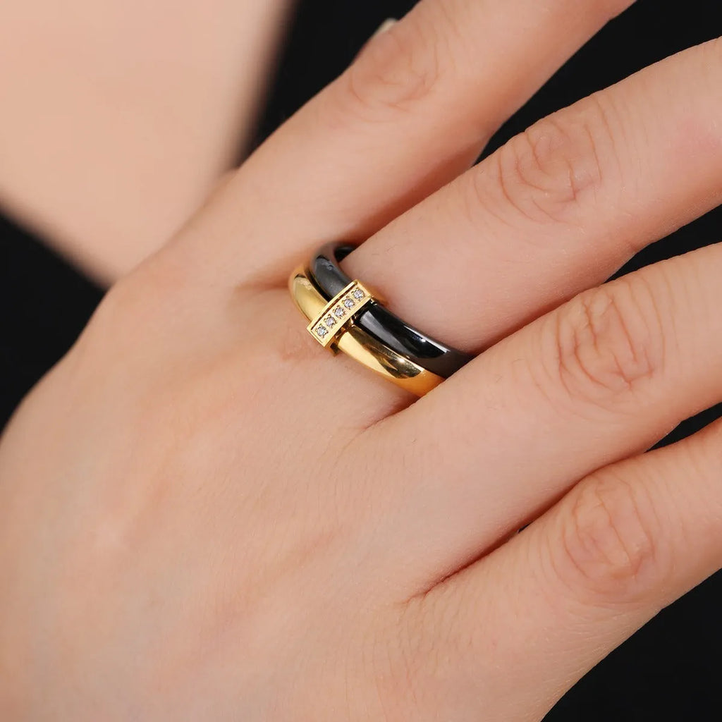 Glossy titanium steel women's ring with zirconium inlay in a heart shape on a double band.
