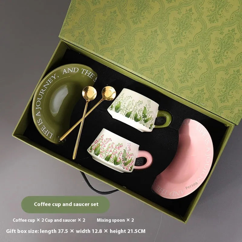 Ceramic coffee cup and saucer set with two cups, two saucers, and two spoons