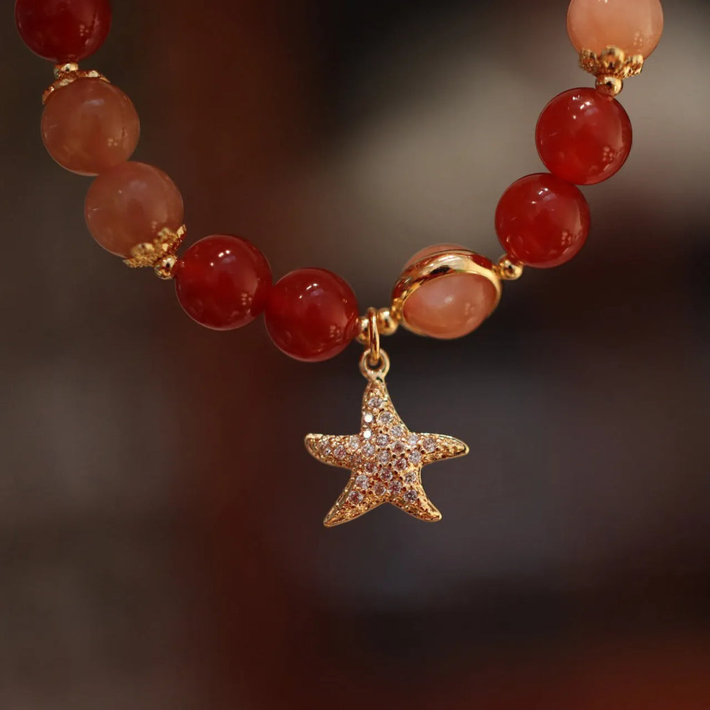 Handmade ethnic-style bracelet with sand orange Sunstone and 8mm red agate beads in a star pattern.