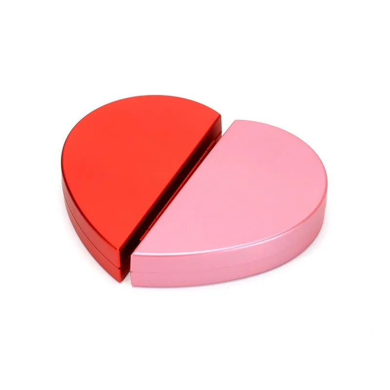 Red heart-shaped plastic ring box on a white background, showing its rotating mechanism.