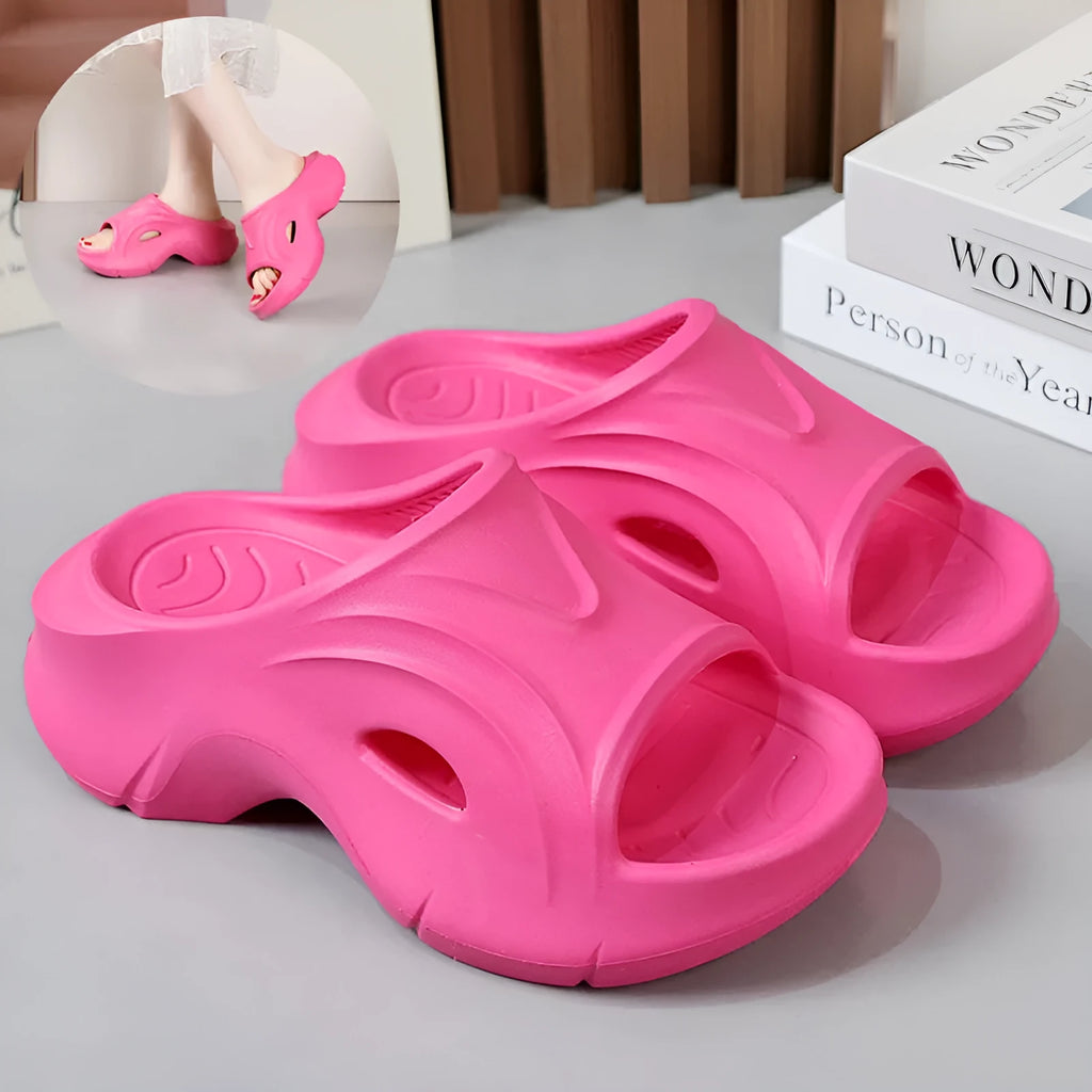 Women's white thick-soled EVA foam slippers with rounded toe on a beach.