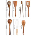A set of seven wooden kitchen utensils including a spoon, a spatula, and several soup spoons laid out together.