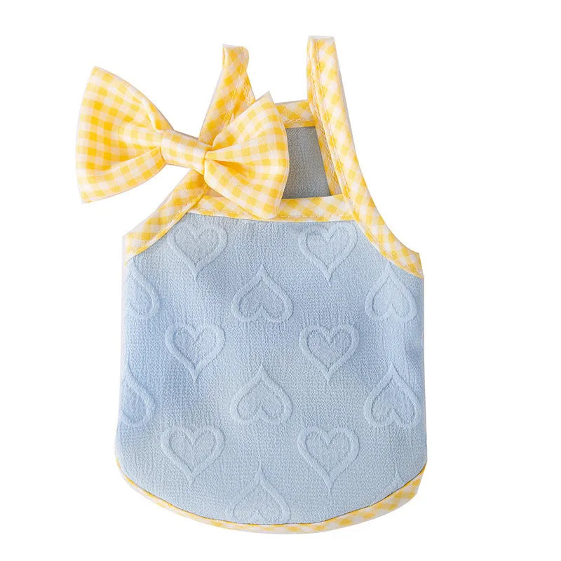 Small dog wearing a blue elastic vest with a heart texture bow on the front.