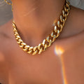 Gold tone thick chain women's necklace on a white background, showing the clasp and extender.