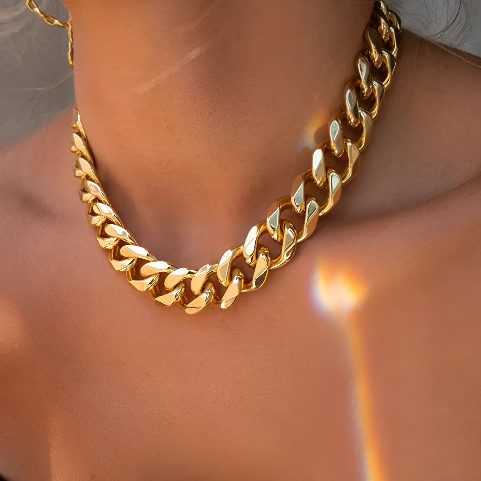 Gold tone thick chain women's necklace on a white background, showing the clasp and extender.