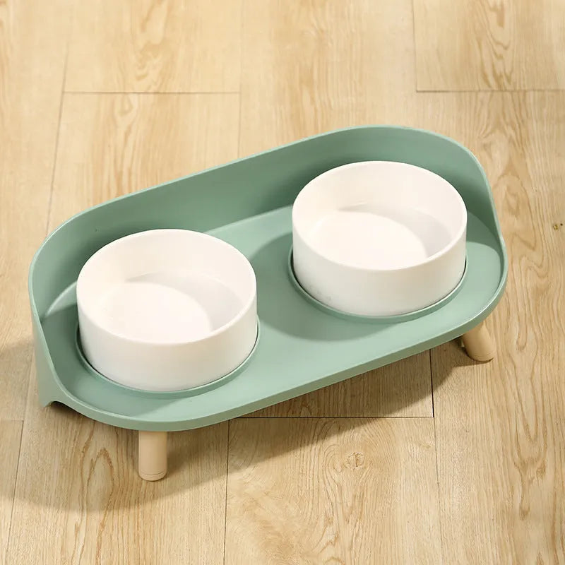Green adjustable tilted double pet bowl for cats and dogs, showing separate food and water compartments.