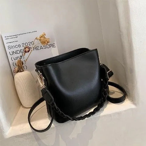 Khaki PU leather bucket bag with woven texture and a crossbody strap.