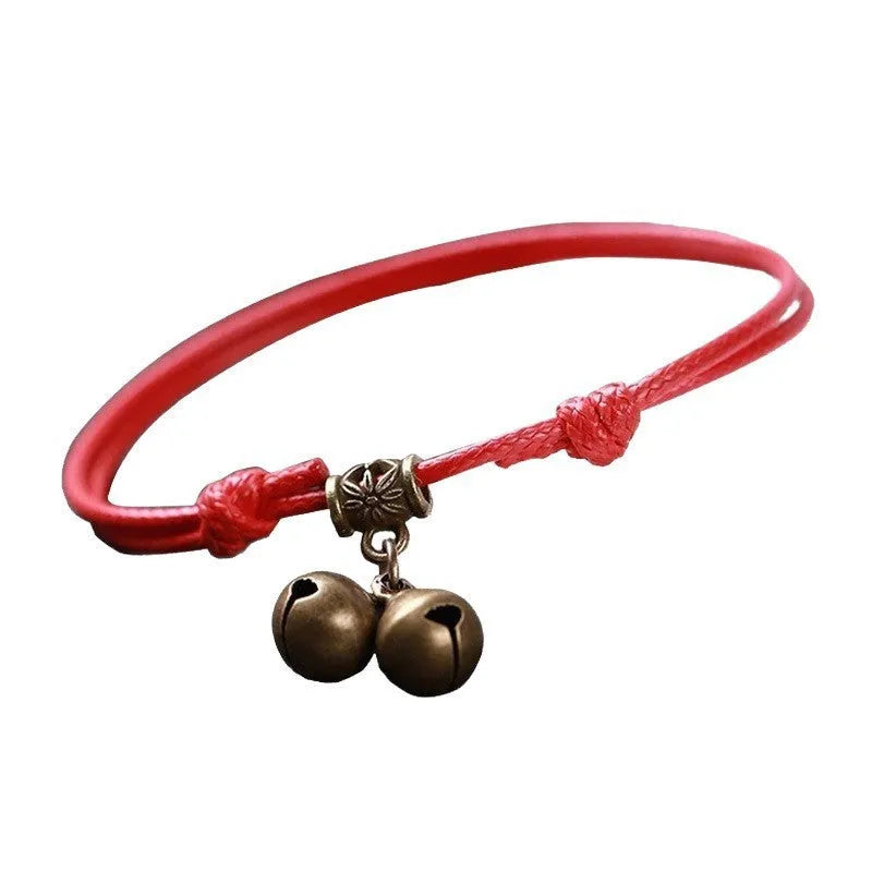 Adjustable nylon dog halter collar with brass bell on black rope, showing brass buckle.