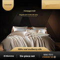 Silk four-piece quilt cover set in a solid colour, shown on a bed.
