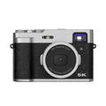 Black 5K HD digital camera with dual lenses and an optical viewfinder on a camera strap.