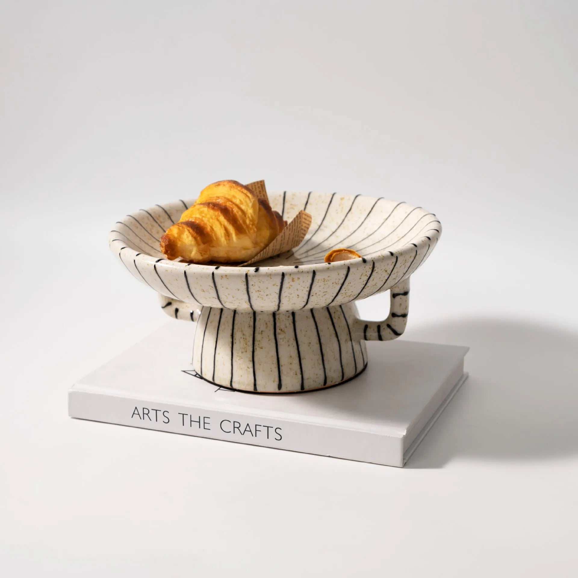 Black and white striped synthetic resin fruit plate on a wooden table.