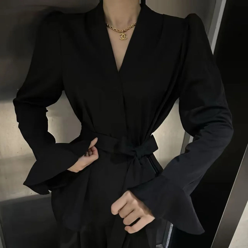 Women's black French-style shirt with irregular collar, tied front, and long flared bell sleeves