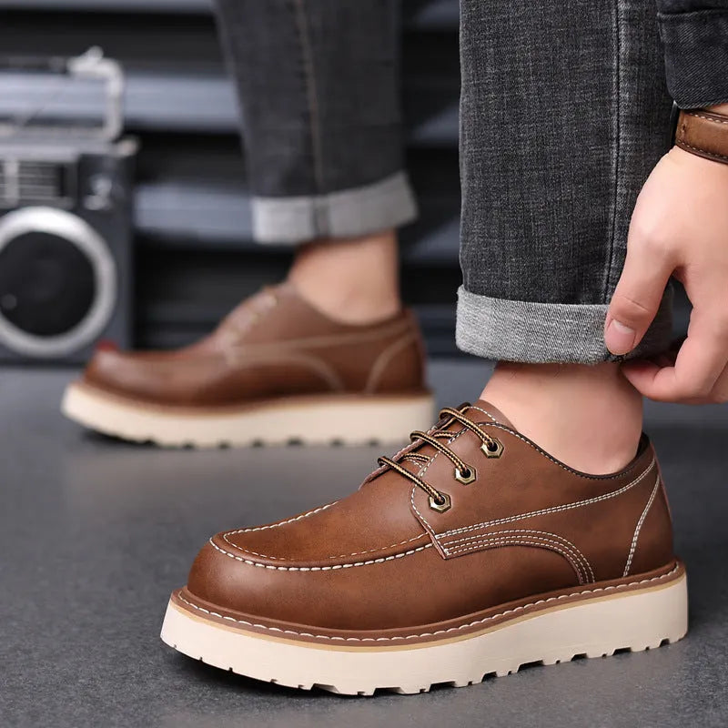 Men's low-top black Martin boots with round toe and rubber sole on a neutral background.