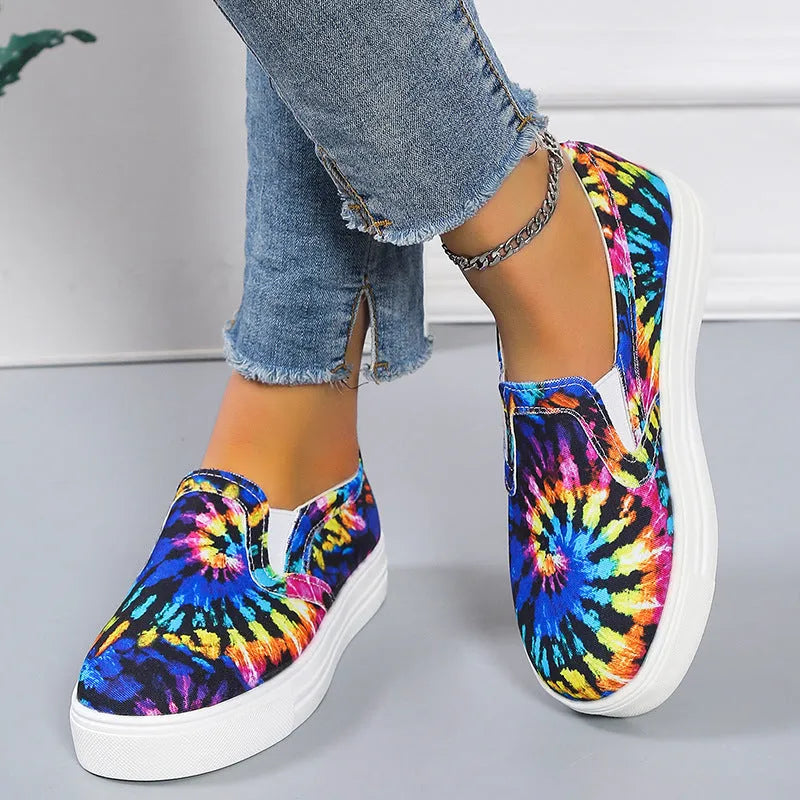 Women's low-top canvas trainers in blue, green, black and colourful patterns with a flat rubber sole.