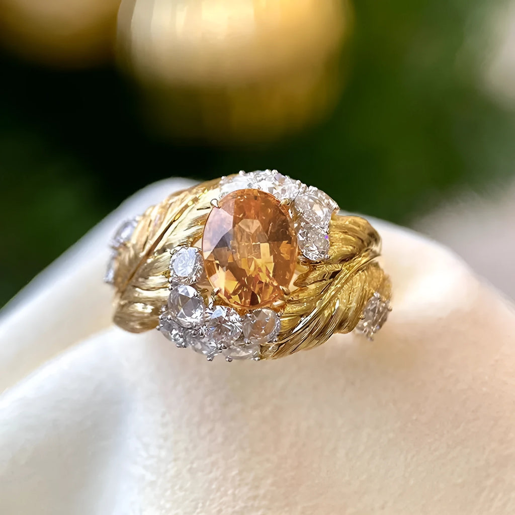Gold-coloured copper ring with embossed feather design and inlaid yellow zircon stones.