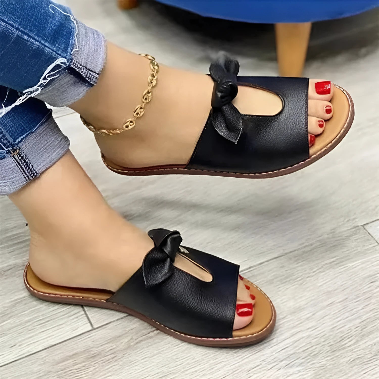 Ladies black sandals with fish mouth toe and a gold bow on the strap.