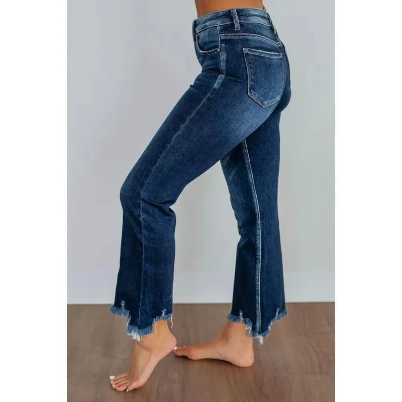 Women's dark blue cotton denim jeans with hand-worn distressing detail on the front.