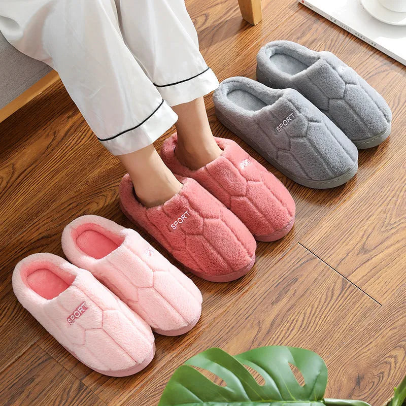 Unisex plush house slippers with white honeycomb-patterned PVC sole, showing round toe and plush inner lining in purple colour