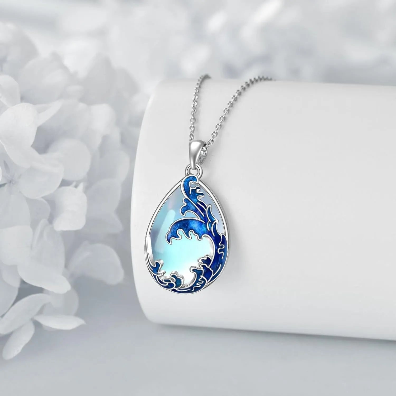 Close-up of a moonstone blue heart-shaped alloy pendant on a necklace chain.