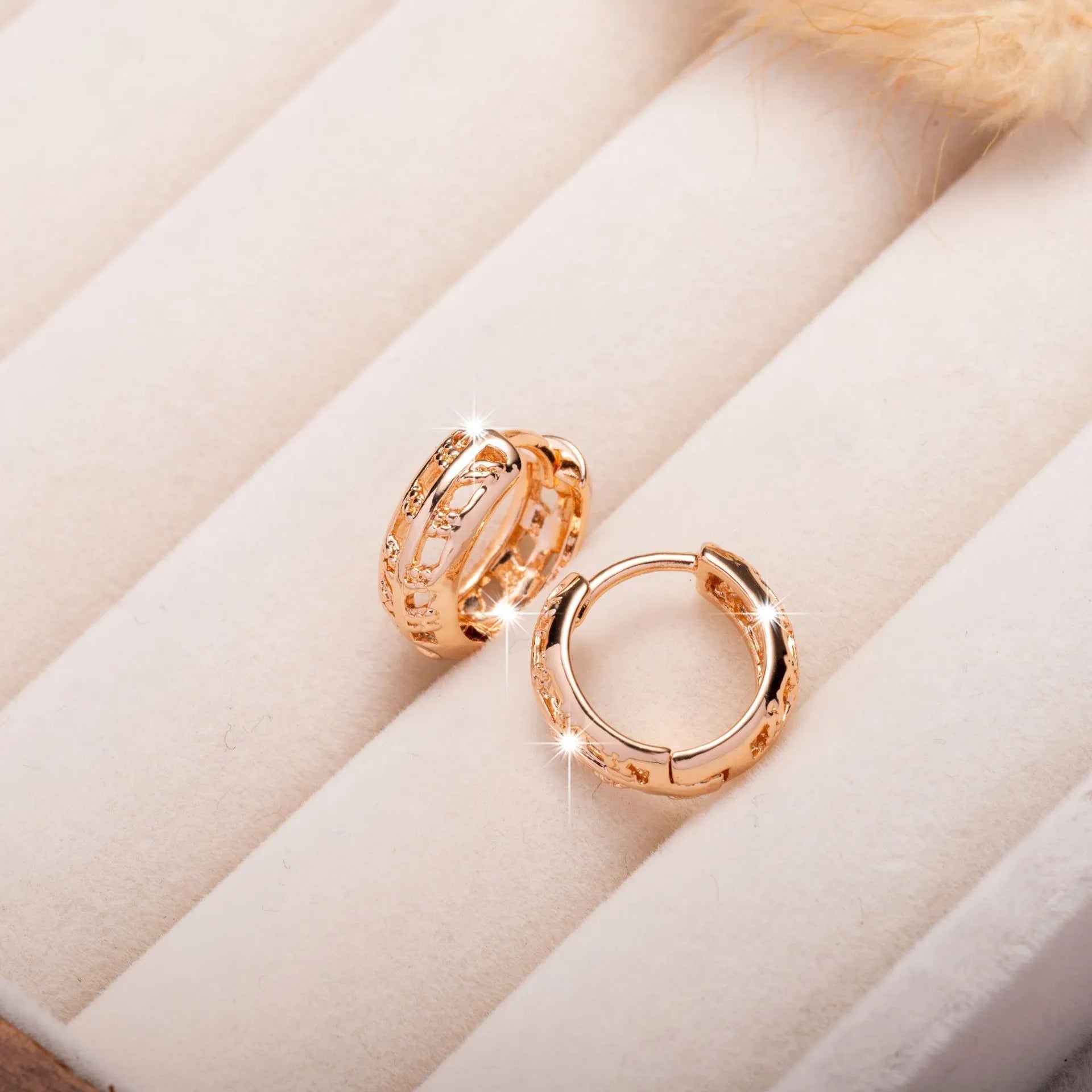 Small copper earrings with a hollow leaf and heart design in a rose gold finish.