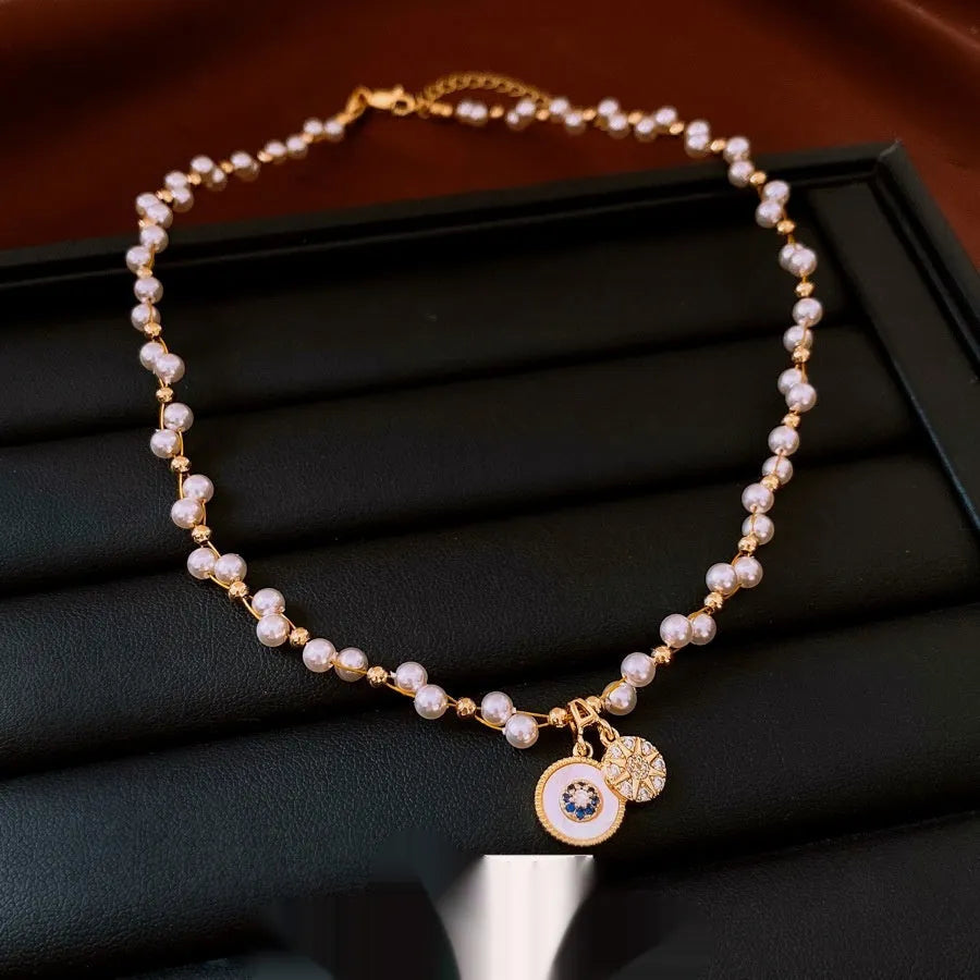 Gold electroplated necklace with round imitation pearl pendant featuring zircon details on adjustable clavicle chain