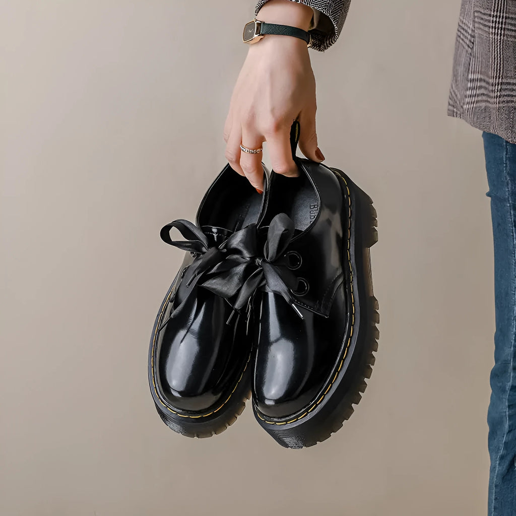 Women's black thick soled leather shoes with cross straps and lace-up closure