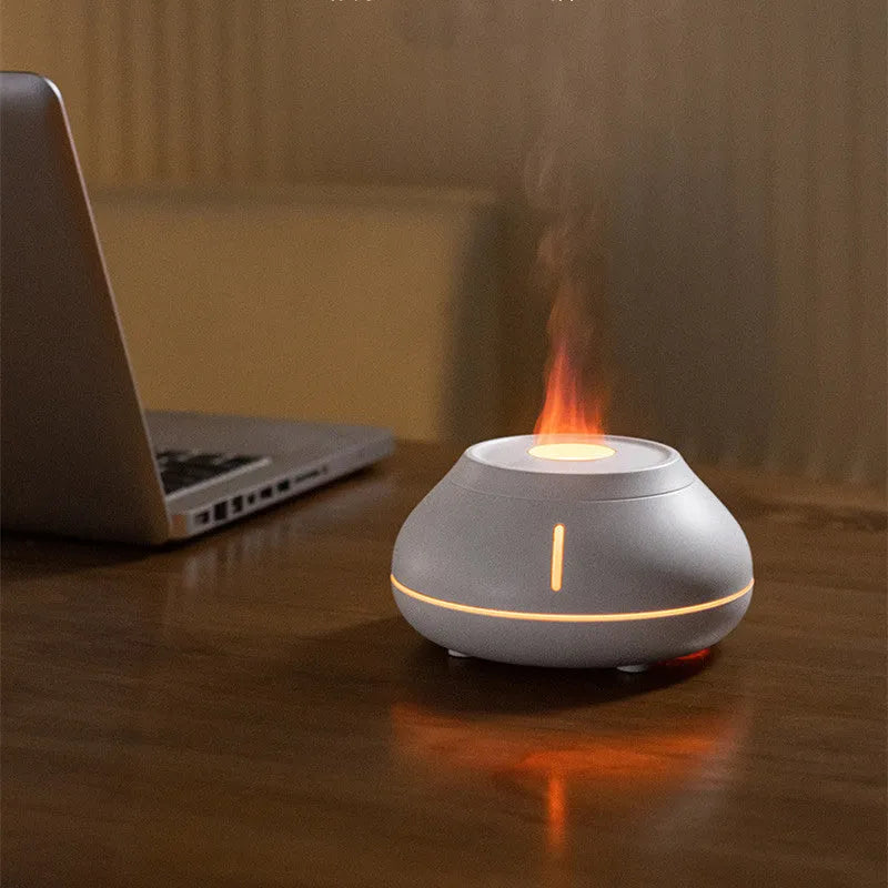 Round white flame effect aroma diffuser humidifier with colourful LED lighting on wooden desk