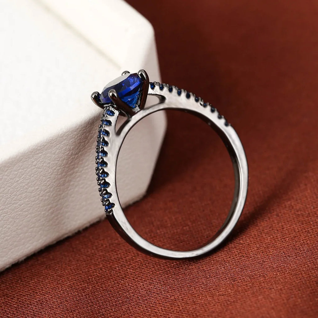 Geometric hexagonal copper ring with colourful zircon stones on a grey background.