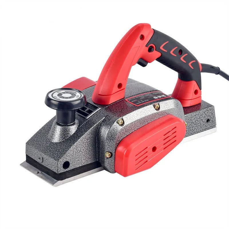 Red desktop electric wood planer with aluminium body on a workbench.