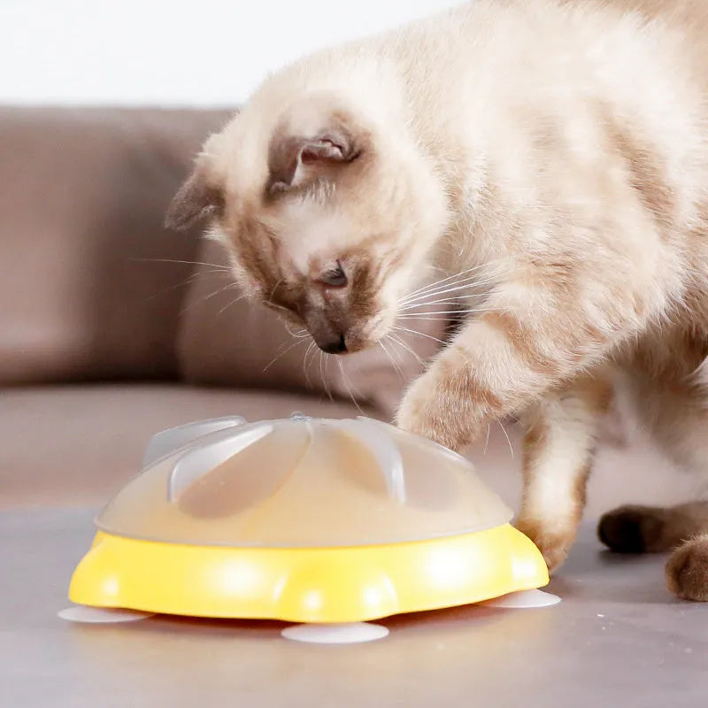 Yellow plastic cat puzzle feeder plate with four rotating balls for slow feeding.