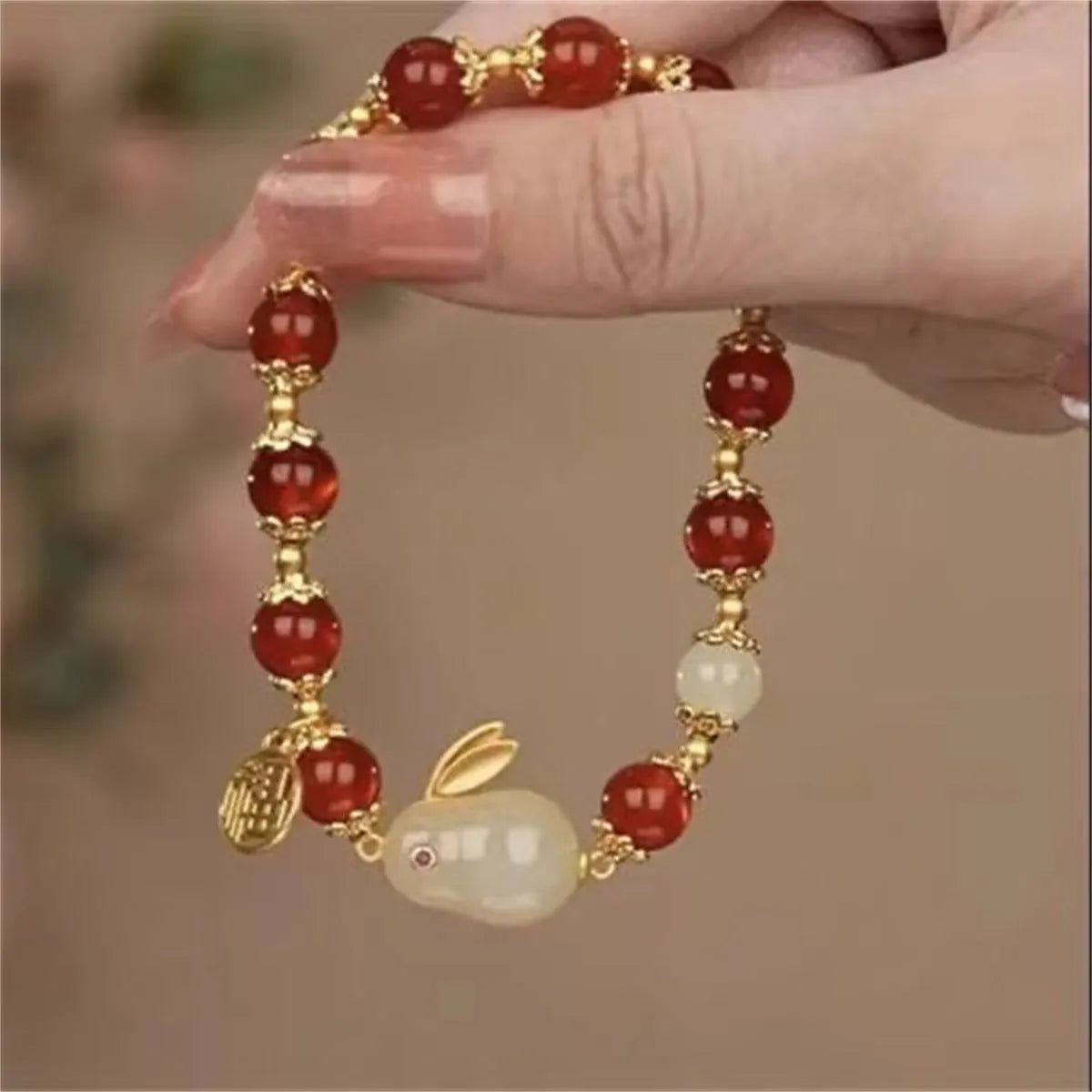 Handcrafted glass peace buckle bracelet with coloured glaze rabbit design on a white background.