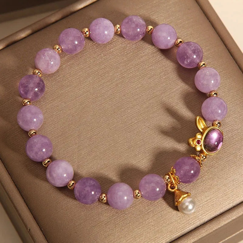 Purplish red mauve jade rabbit head charm on a crystal adjustable Mori-style bracelet.