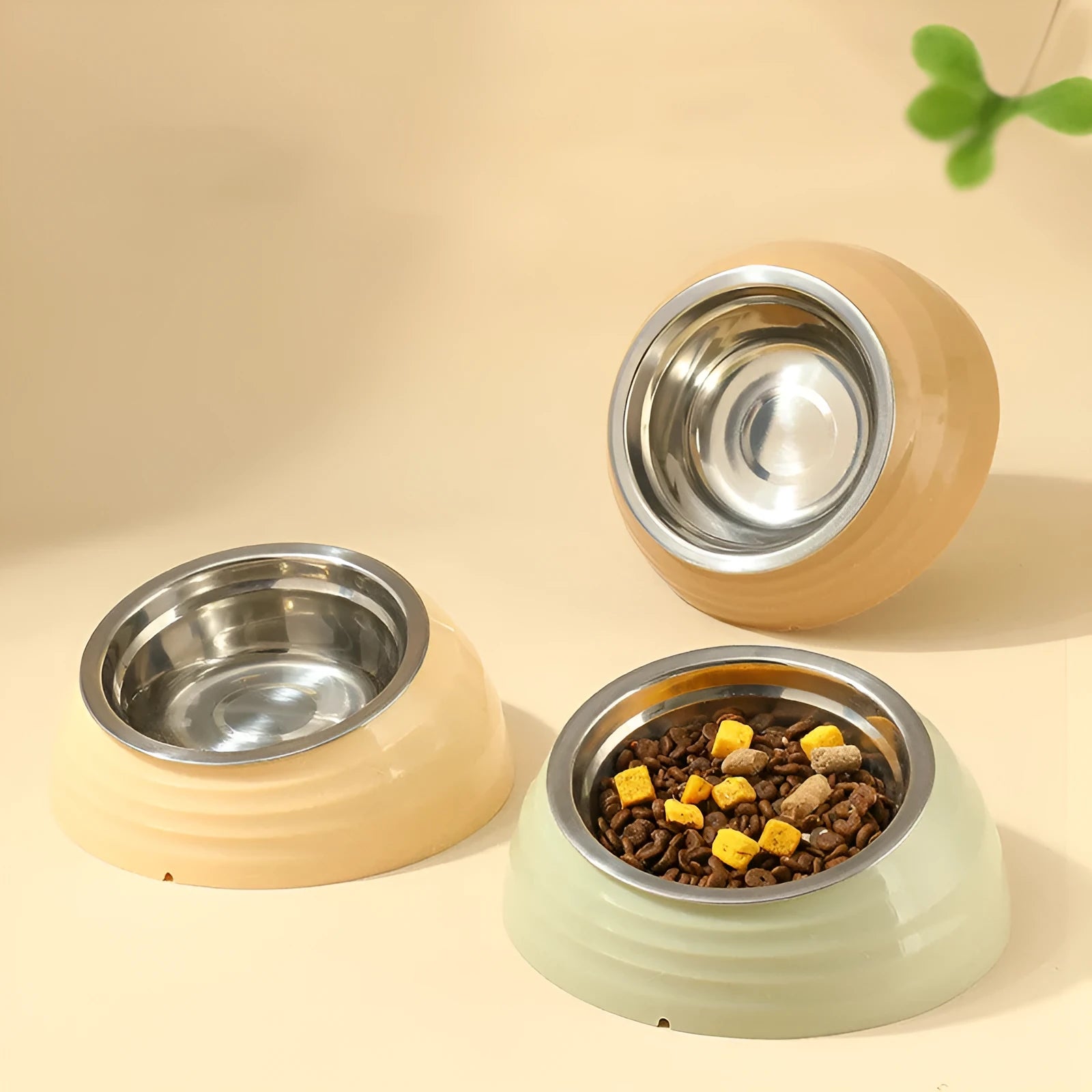 Stainless steel cat bowl in plastic base, shown in light green, beige, and brown colour options.