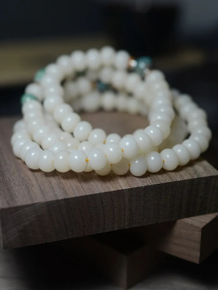 White jade and bodhi seed beaded bracelet with 108 flat round beads in four sizes.
