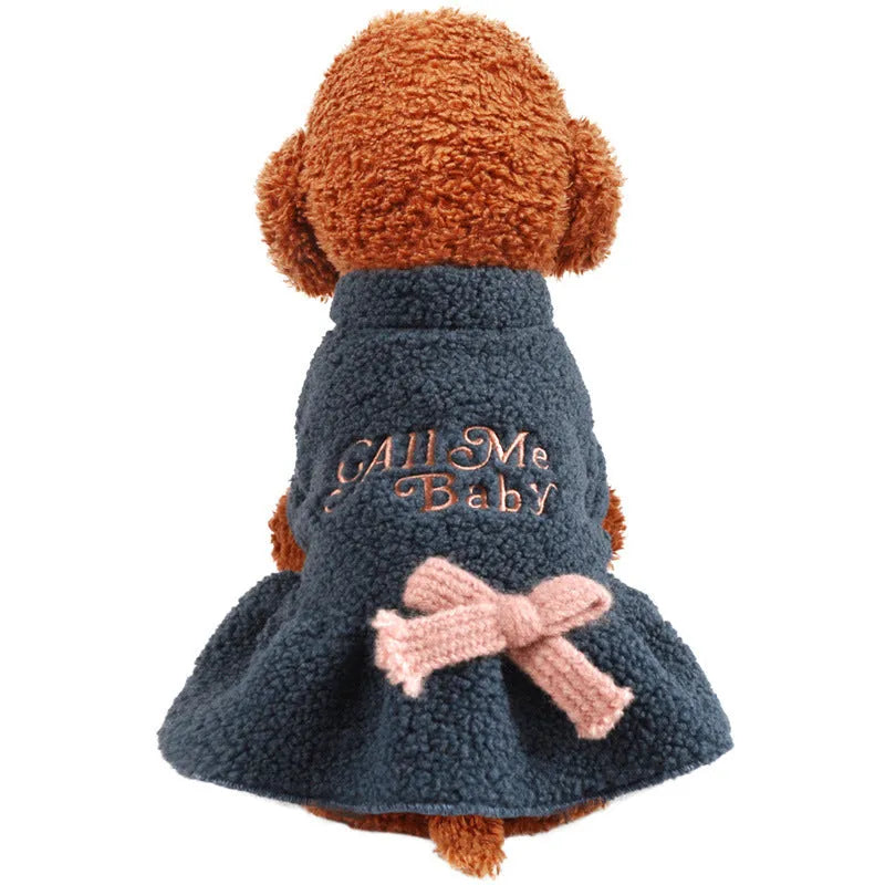 Pet dog wearing a pink baby letter patterned fleece skirt, showing the casual fit and soft polyester material.