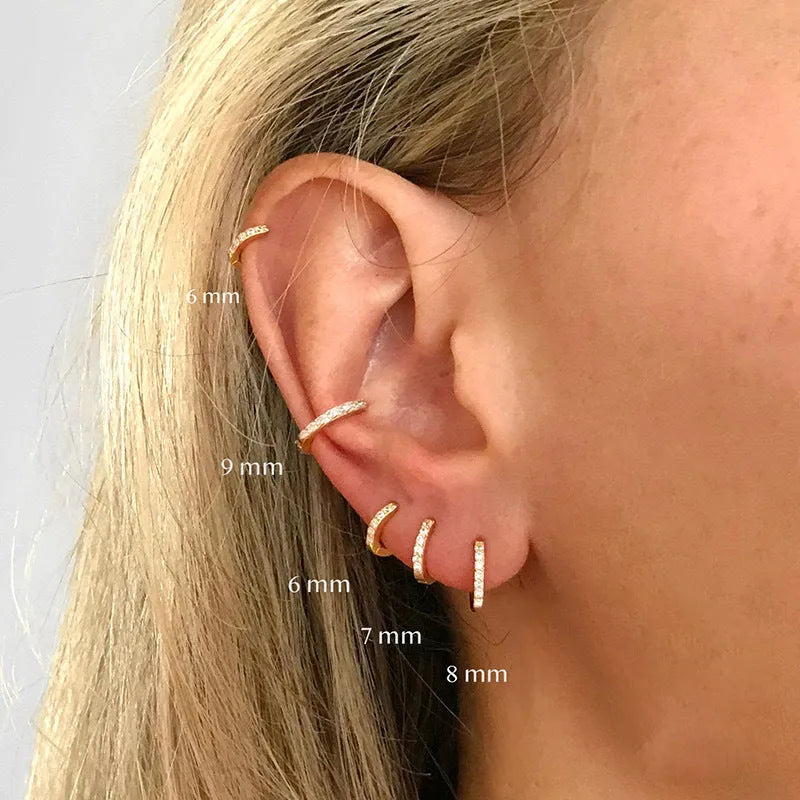 Circular perforated stud earrings in gold, rose gold, and silver colours on a copper base.