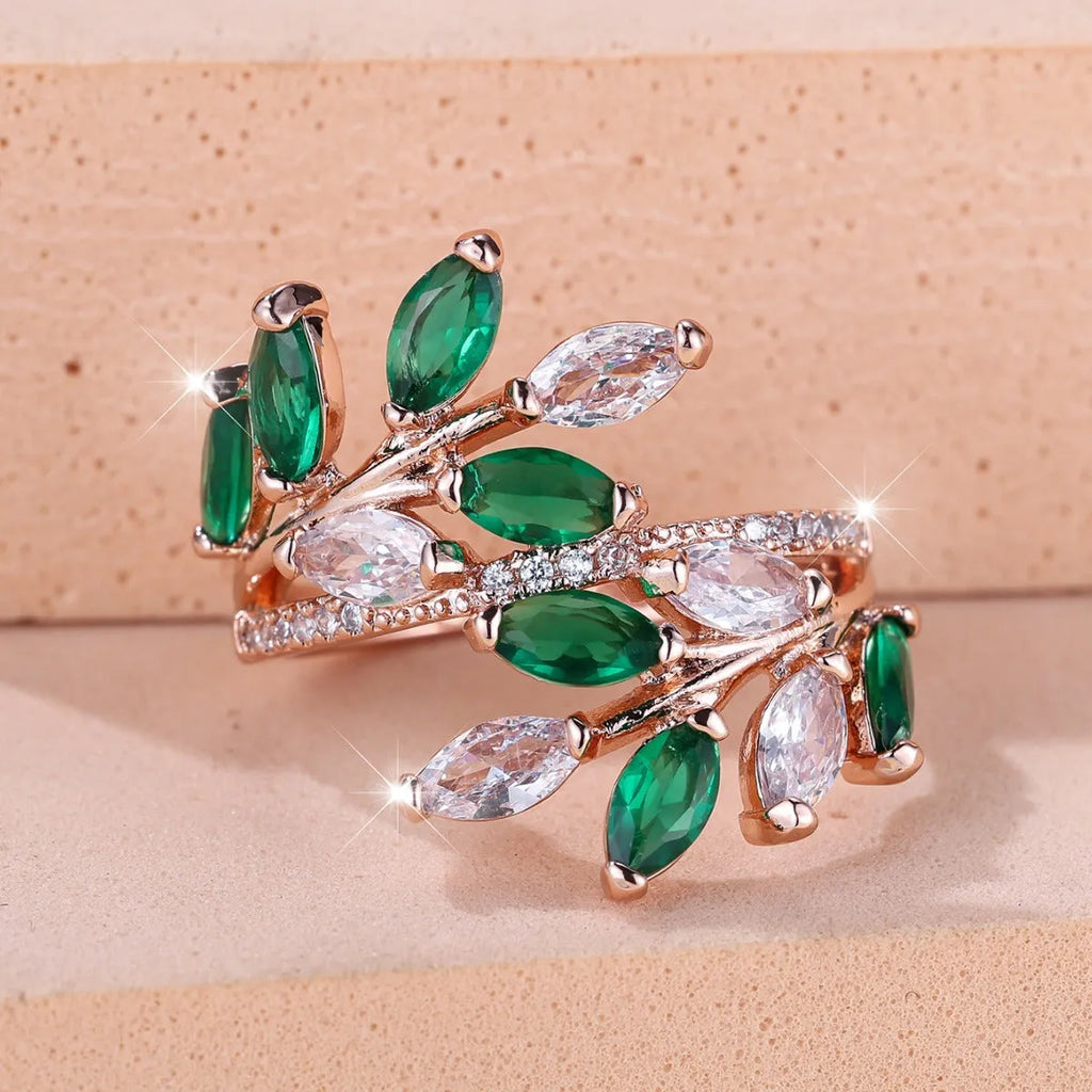 Adjustable copper leaf-shaped ring with zircon stones in various colour options on a white background.