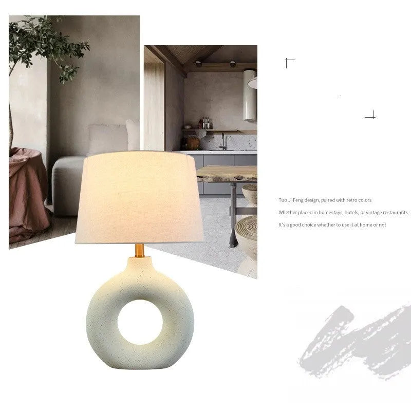 Small white Feng pottery Japanese-style table lamp with button switch on a desk.