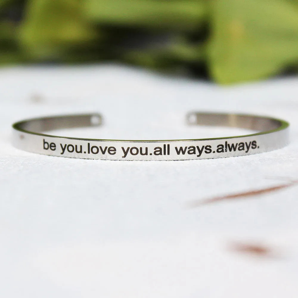 Silver customisable stainless steel bracelet with laser engraved text and adjustable fit on neutral background