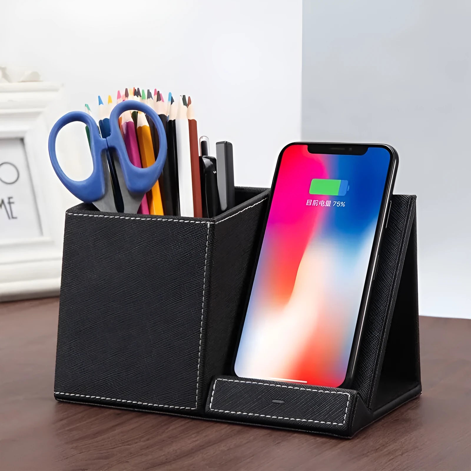 Black leather pen holder with integrated wireless phone charging pad on a desk