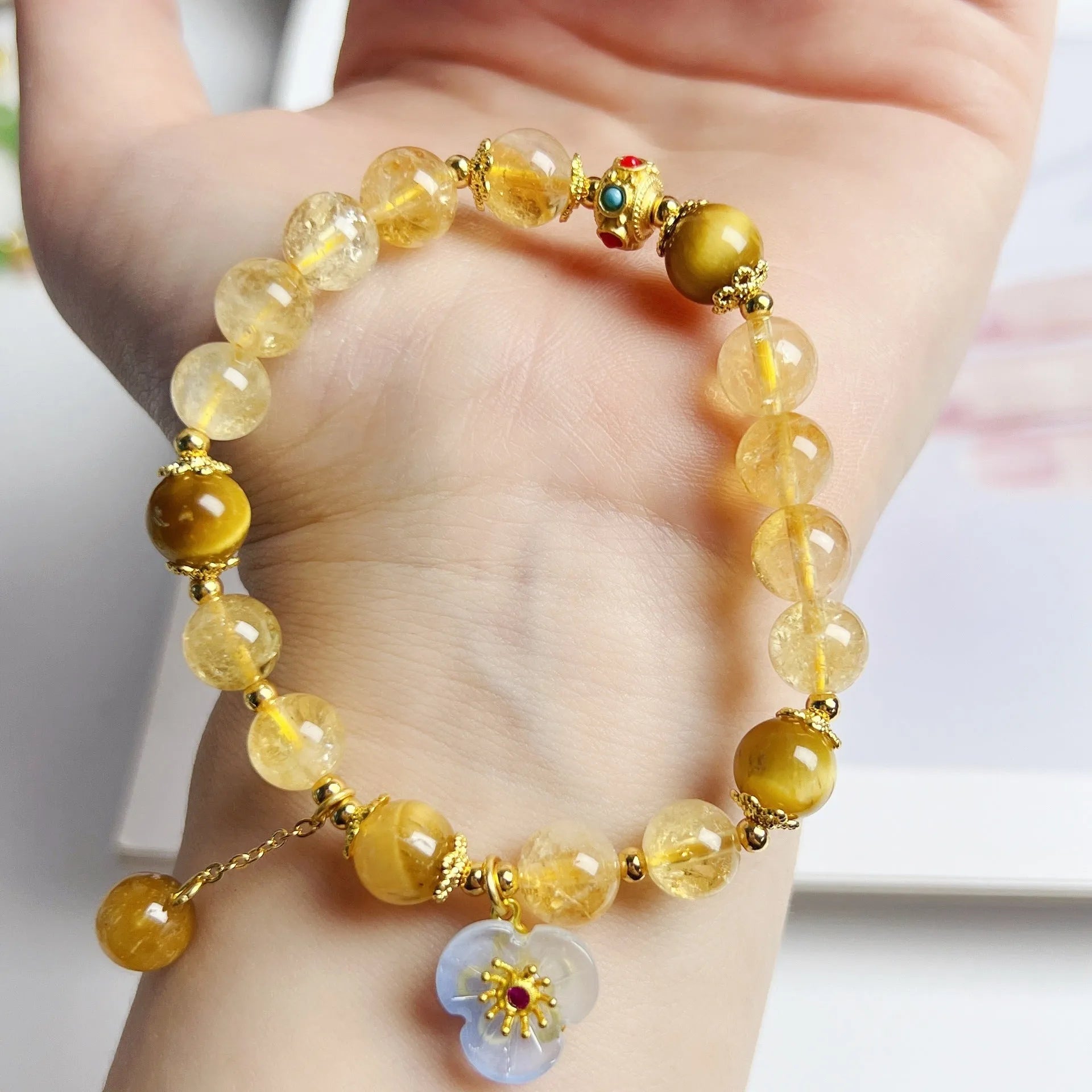 Golden yellow citrine crystal bracelet with flower and tassel detail for women.
